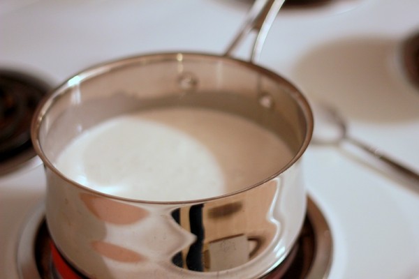 Cách làm chè chuối - đổ nước cốt dừa và đường vào nồi rồi khuấy đều đun đến lúc sôi